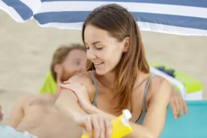 woman putting on sunscreen to avoid getting hyperpigmentation and getting intimate lightening to fix it
