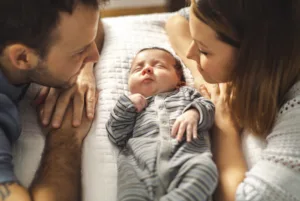 Man and woman looking at the baby while the mom thinks about vaginal rejuvination