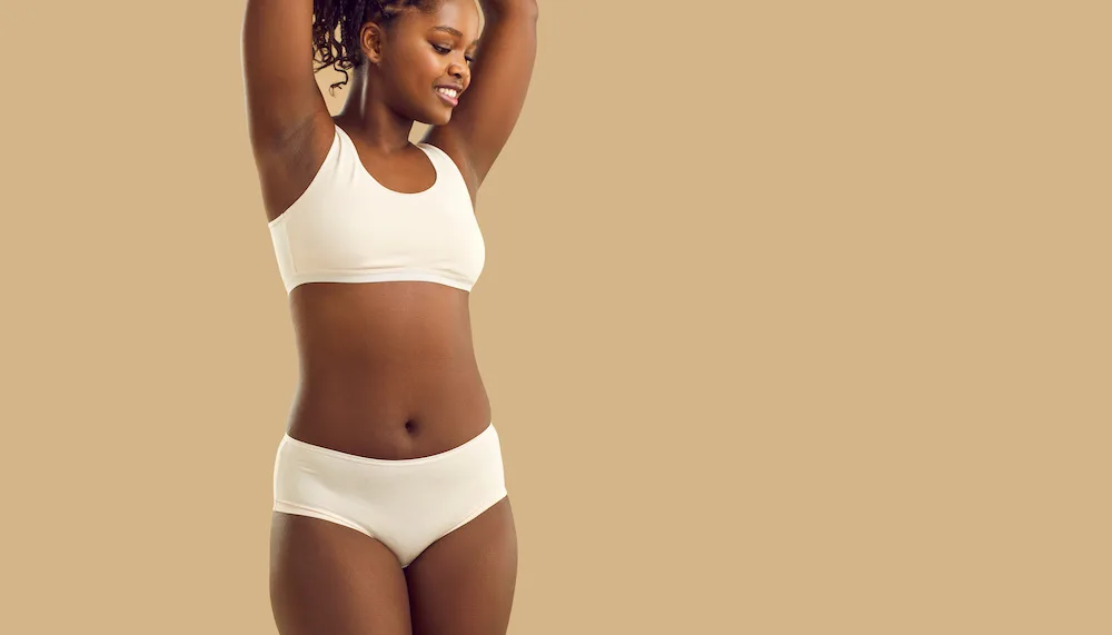 happy woman after having a monsplasty on a tan background