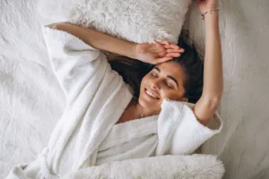 happy woman in her bed after getting a clitoral hood reduction