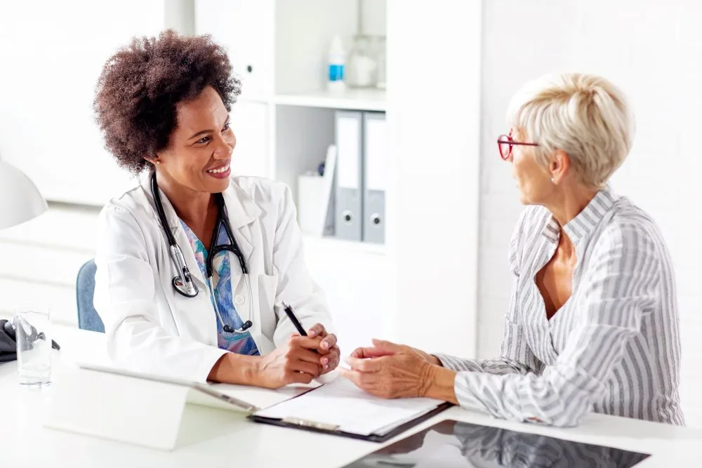 A female doctor speaking with her patient about the benefits and safeness of a procedure.