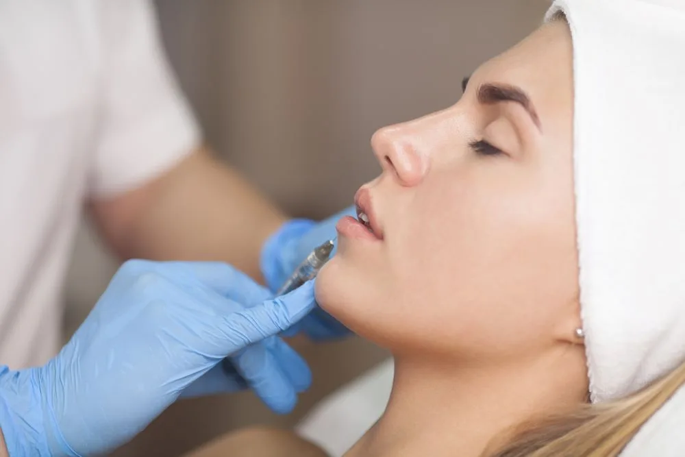 A woman receiving a lip injection treatment at a medical spa.