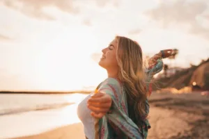 A woman feeling free while dancing on a beach.