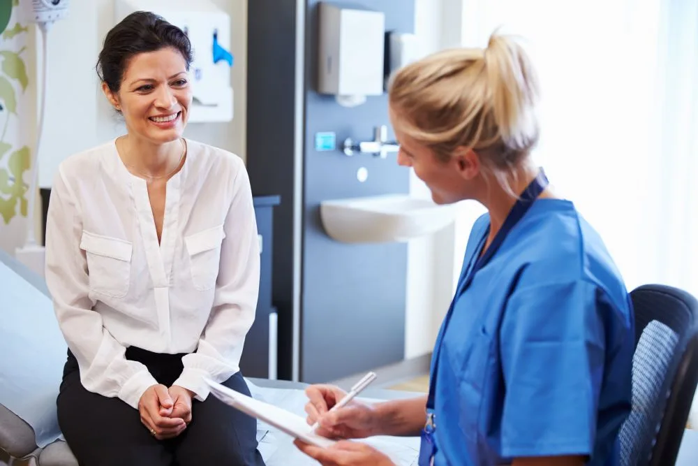 A woman speaking to her nurse about treatment options.