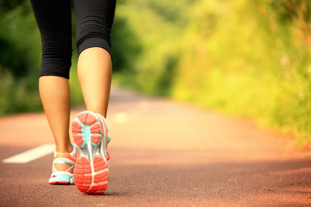 A woman walking on a hiking trail.