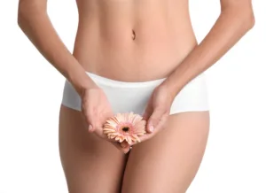 Woman with gerbera flower on white background. Gynecology concept.