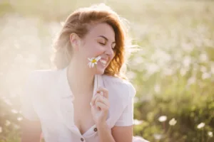 Young woman relaxing in chamomile field.