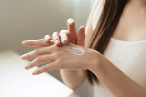 Woman applying a skin bleaching cream on her hand to test out the results.