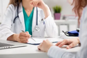 A woman speaking to her doctor about needing another surgery to fix errors from her first surgery.